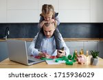 Small photo of Father Working from home on laptop during quarantine. Little child girl make noise and distracts father from work on the kitchen office