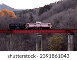 Small photo of Hokkaido, Japan - 11／5／2023: A diesel locomotive pulling a coal scuttle train is displayed on an abandoned railway bridge in the evening.
