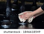 Small photo of A groom washing hoofs and legs of horse in shower after training