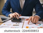 Small photo of Investors are calculating profits and costs with calculators, growth and investment chart analysis, business planning and strategies to maximize sales profits. Long term business plan.