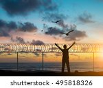 silhouette prisoners were imprisoned on the island alone, praying and free bird fly over blurred nature sunset background. hope and people concept and international day of peace.