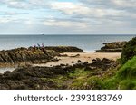 Small photo of Helens Bay, County Down, Northern Ireland October 10 2023 - Family playing in the rock pools on Helen's Bay beach