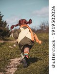 Small photo of Girl in Pippi costume running back view