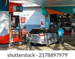 Small photo of SINGAPORE - 16 JUL 2022: A pump attendant tops up petrol in a car at the Caltex petrol station in Upper Thomson Road. Most attendants are elderly.