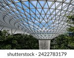 Small photo of SINGAPORE - 7 FEB 2024: The dome of the HSBC Rain Vortex has pipes in its fins discharging water into the central part. At 40 metres high, the Rain Vortex is the world's tallest indoor waterfall.