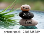 Small photo of Mind, Body and Soul words engraved on zen stones with space for text. Copy space and zen concept
