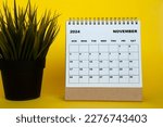 November 2024 month calendar with table plant on yellow cover background. Monthly calendar concept.