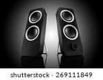 Computer speakers on black background with reflection