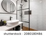 Simple bathroom with black shower, round mirror and classic white tiles