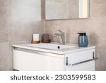 Small photo of Close-up of comfortable large sink with a mirror in toilet with beige tiles, a soap dish and candles. Concept of convenience and conciseness in interior design