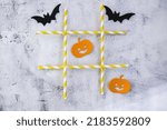 Small photo of Creative tic tac toe game made of halloween decorations. Ghost bat pumpkin Autumn party concept Craft diy children game