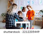 Small photo of Development class for math, alphabet and logic. Teacher with children having fun and learning in kid development childcare center for preschoolers. Nursery school and early education for little genius