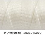 A coil of white thread. Spool of colored threads on a white background. Waxed sewing thread for leather crafts.