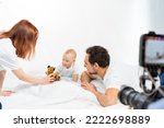 family with a child. Happy family is sitting on the floor. Father, mother and child have fun together. minimalist interior. baby photoshoot in studio