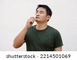 Small photo of Asian man uses inhaler to smell for relieve dizzy and faint symptoms. Concept : health problem, sickness and remedy. Increases freshness, reduces dizziness and stuffy nose. self take care.