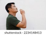 Asian man uses inhaler to smell  for relieve dizzy and faint symptoms. Concept , health problem, sickness and remedy. Increases freshness, reduces dizziness and stuffy nose. self take care.           