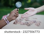 Small photo of Closeup hand holds magnifying glass to inspect palm lines. Concept , palmistry, astrology. Foretelling, mystery, magic, fortune, fate. Prediction for future life , events. Palmist predicting.