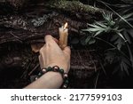burning candles and a womans hand with a bracelet on a dark natural background. pagan wiccan, slavic traditions. Witchcraft, esoteric spiritual ritual for mabon, samhain. 