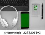 Small photo of calendar date on a light background of a desktop and a phone with a green screen. June 28 is the twenty-eighth day of the month.