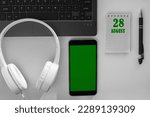 Small photo of calendar date on a light background of a desktop and a phone with a green screen. August 28 is the twenty-eighth day of the month.