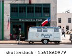 Small photo of WACO, TEXAS - MARCH 22 2019: Central city Waco showing wear and age. Barnett's Pub and Nightlight Donuts two staples are shown with American and texan flags hanging. The food truck covers the facade.