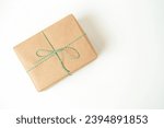 The gift is wrapped in kraft paper on a white background. Isolate on a white background. Top view. 