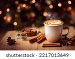 Small photo of Steaming hot caramel latte in glass mug on wooden background, cinnamon sticks, christmas mood