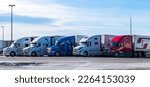 Small photo of Sommerset, Pennsylvania, USA February 5, 2023 Five 18 wheeler freight trucks lined up at a rest stop on a sunny winter day