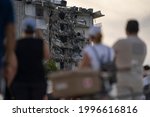 Small photo of MIAMI, FL, UNITED STATES - JUNE 24, 2021: People watch a partially collapsed building in Surfside north of Miami Beach.