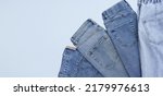 Small photo of Lots of jeans pants in a stack. Denim background. The concept of buying, selling, shopping and trendy modern clothes.