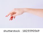 Female hand with red manicure on light grey background