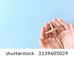 Small photo of Top view of hand holding wooden cross crucifix with copy space in blue background. Catholicism, Christianity, Thanksgiving, Catholic and Christian faith concept.