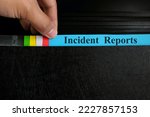 Small photo of Hand picking incident report file in black binder folder. Corporate business concept.