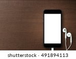 phone blank screen and headphone on wood table, mockup new smartphone style