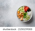 Small photo of Salmon poke (buddha bowl) with avocado puree, cucumber cubes, pickled ginger, dry nori seaweed, cream cheese, sesame seeds and rice. Healthy seafood dish, lunch or dinner. Top view. Copy space.