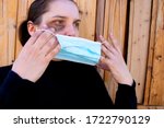 A woman is trying to hide traces of domestic violence by wearing a medical mask. The concept of rising domestic violence during quarantine isolation COVID-19.