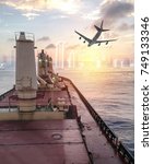 Small photo of General cargo ship argosy cruising on ocean with plane to urban city at sunrise morning