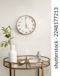 Small photo of Styled Home Still Lifestyle Image. Side Table with Wall Clock and Vase with Eucalyptus Leaves.