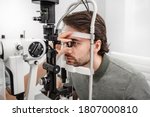Adult man eyesight test with binocular slit-lamp. Checking retina of a male eye close-up. Ophthalmology Clinic