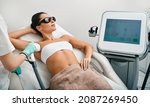 Small photo of Young woman receiving underarm laser epilation and armpit hair removal using medical laser