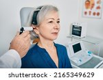 Small photo of Elderly woman receives tympanometry with tympanometer probe at hearing clinic. Hearing check-up, impedance audiometry