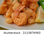 A closeup of a deep fried shrimp a plate portion for menu restaurant