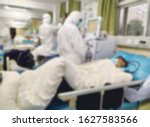 Small photo of Paramedics working to isolated corona virus suspect in blurry view. viruses that include the common cold, and viruses such as SARS and MERS. This new virus was named "COVID - 19"