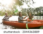 Happy couple kayaking on the river surrounded by trees, enjoying adventurous experience. Leisure, sport concept