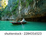 Small photo of Ha Long, VIETNAM MAR 12 2023: Tourist junks floating among limestone rocks at Ha Long Bay, people kayaking inside of a cave in Lan Ha Bay, close to Halong Bay, Vietnam