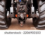 Small photo of Tow hitch of a modern tractor with safety and insurance locks. selective focus