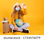 Small photo of A tourist girl with a medical mask, outbreak of coronavirus COVID-19. Concept of canceled trips. A tourist cannot leave due to a pandemic.
