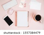 Minimal women office desktop with keyboard, laptop mouse, phone, pen, coffee mug and notebook on pink background. Flat lay, top view, space for text.