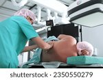 Small photo of Epidural anesthesia. Injection for spinal anesthesia. Nerve blockage. An anesthesiologist at work.