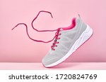 Pair of fashion stylish sneakers with flying laces, Running sports shoes on pink background